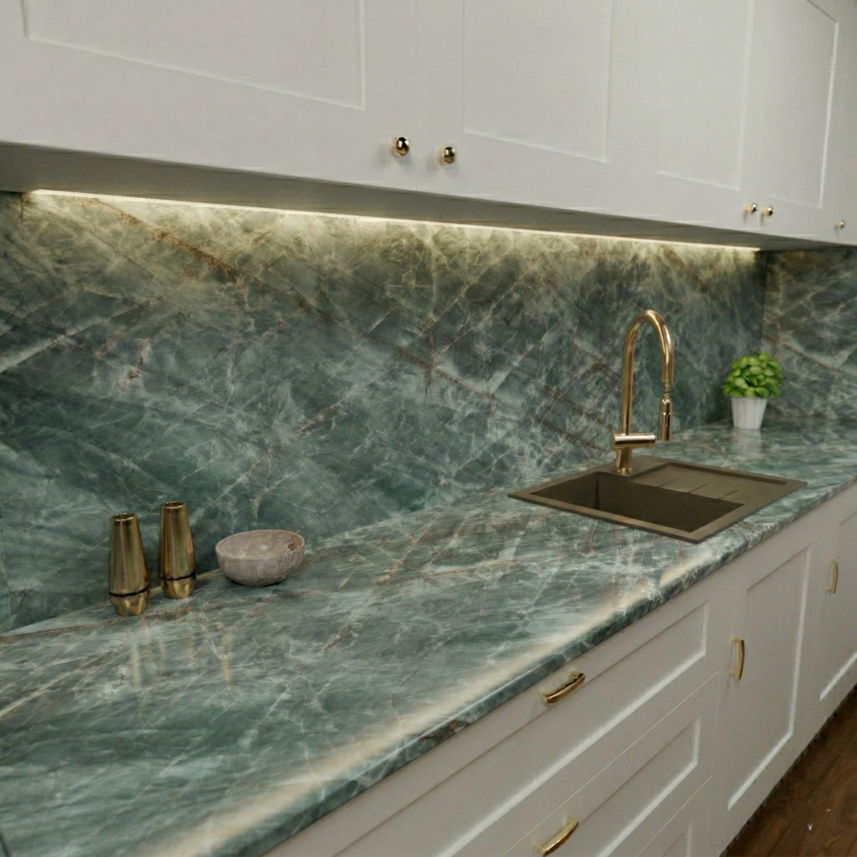 Zdjęcie przedstawia fragment kuchni z białymi meblami i blatem z kwarcytu naturalnego emerald marbec w kolorze zielonym z jasnymi żyłkami